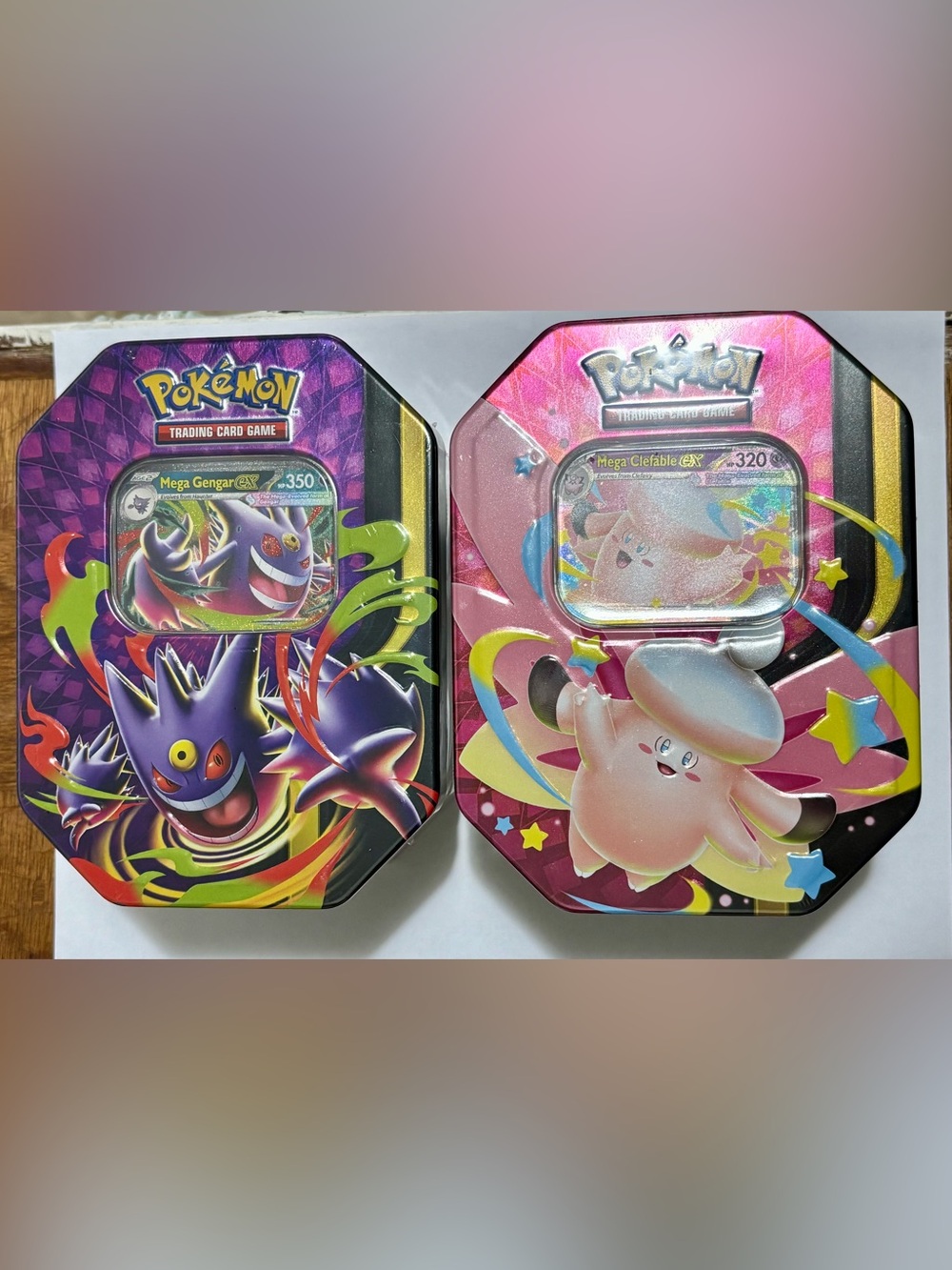 Pokemon Collectible Tins Featuring Mega Gengar (purple) & Mega Clefable (pink)